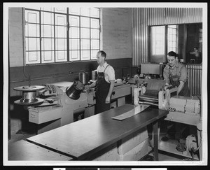 Employees of the Handy and Harman Company working with wire drawing and sheet flattening facilities for silver alloys, ca.1935