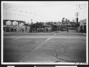 Pico Boulevard bus terminal, with buses and a trolley car, April 12, 1937