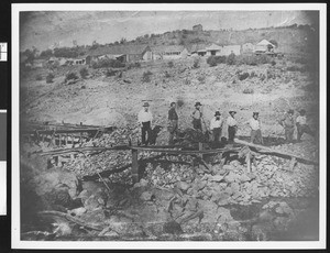 Several miners posed amongst rocks in Parks Bar in Yuba County, 1900-1940