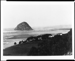 View of Morro Rock and Bay near San Luis Obispo, showing a grassy knoll in the foreground, ca.1900