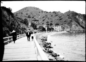 People walking on a wooden sidewalk near Avalon Harbor