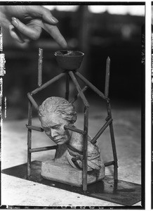 Bronze statue of a head being supported by a metal framework