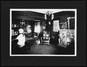 Interior view of a residence showing a woman seated at a piano