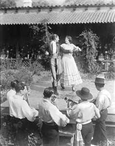 Portrait of Spanish dancers and accompanying musicians outside at the Southwest Museum's Casa Adobe, Los Angeles, ca.1930-1939