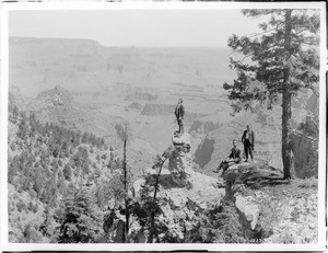 Three hikers at Pulpit Rock near the Grand Canyon Hotel in the Grand Canyon, ca.1900-1930