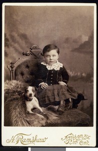 A portrait of a young child with a dog