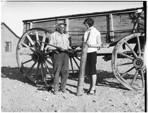 Man and woman standing in front of a wagon