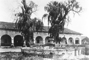 Exterior view of the Mission San Fernando Rey de Espana, showing the fountain, ca.1890