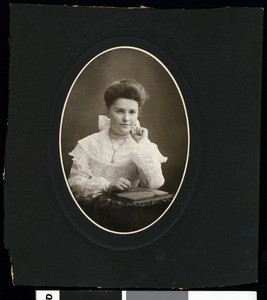 Portrait of a young woman leaning on a desk