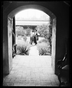 Mexican couple standing in front of a fountain as viewed through a breezeway