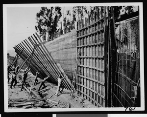 Workers erecting an unidentified wall