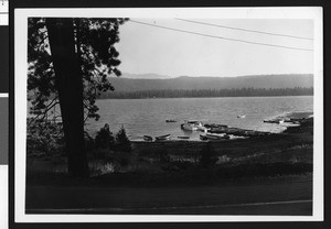 Big Bear Lake, showing a dock with boats at the near shore, ca.1950