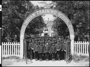 Exterior view of a group of young boys near the entrance to the Indian Training School in Chemawa, Oregon, ca.1900