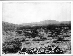 A low pile of stones mark the grave of George Anderson in the Mojave Desert, ca.1898