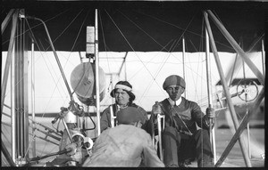 Indian girl and a man in the cockpit of an airplane at the Dominguez Hills Air Meet, 1912