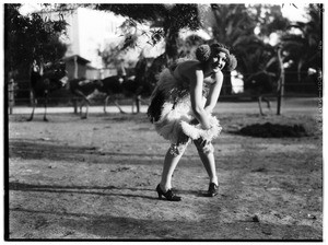 Woman in flapper's dress dancing at an ostrich farm in Lincoln Park