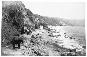 A view of Arch Rock in Santa Monica, showing a group of men posing along the rocks nearby, ca.1880