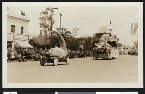 Parade with floats and flags flying, ca.1920