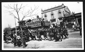 View of a parade of people holding up a large ornamental banner