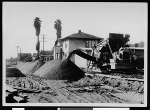 Department of Public Works employees using a Parsons Trenching Machine during road construction