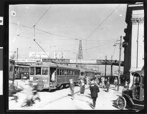 Electric cars of the Municipal Railway passing under a bridge within a crowded city, San Francisco, ca.1920