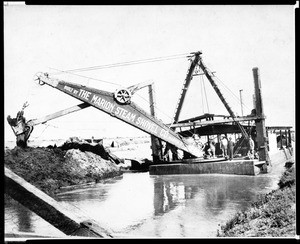 View of canal dredging in Venice, showing a steam shovel on a barge, ca.1900-1909