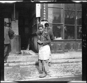 Portrait of a store clerk on the sidewalk in China, ca.1900