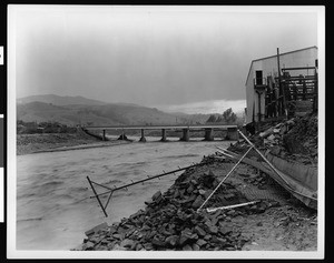 Flooding and damage along a drain pipe in Studio City, showing a bridge, 1938