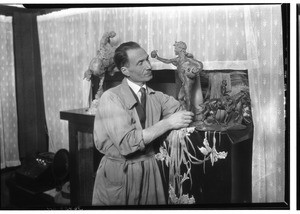 Man examining a statue of a man holding an apple