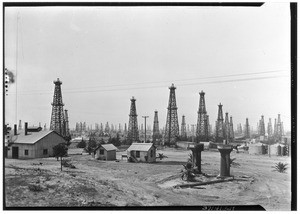 A few buildings in front of an oil field