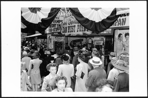 Close-up of a crowded sidewalk outside of a theater on Broadway near 7th Street, Los Angeles, March 1, 1942