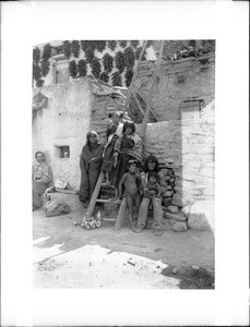 Hopi Indian family at the ladder leading to the entrance of their dwelling, ca.1900