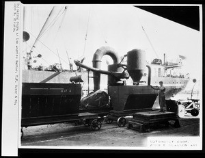 Man unloading copra from a ship into small rail cars for the W.F. Sutor Corporation at Los Angeles Harbor