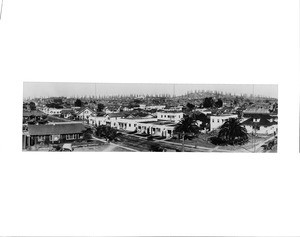 Panoramic view of residences in Signal Hill, Long Beach, showing oil derricks in the distance, ca.1925