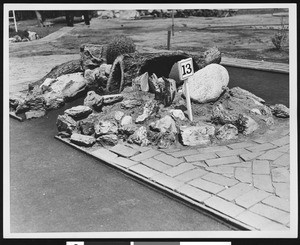 A close-up view of a miniature golf hole numbered "13", ca.1930