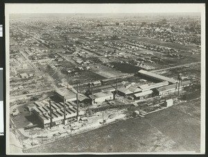 Aerial view of unidentified factory and surrounding city, ca.1930