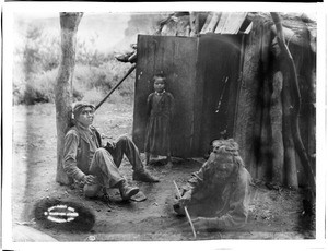 Three Havasupai Indians, Waluthama, his father and daughter, in front of their "Hawa" or dwelling, ca.1899