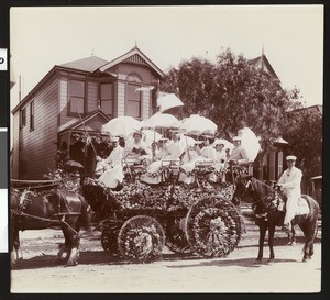 Women with parasols in a flower decorated cart at La Fiesta de Los Angeles, ca.1900