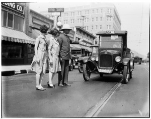 Officer stopping traffic so two women can cross the road