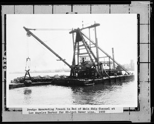 View of a dredge excavating a trench in the main ship channel at Los Angeles Harbor for a twenty-inch sewer line, 1933