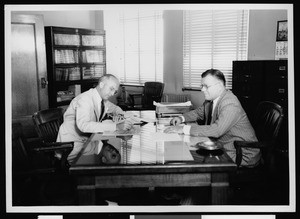 Two men at a desk in the Department of Public Works