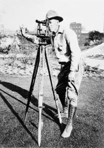 Portrait of a surveyor operating a theodolite, 1920-1930