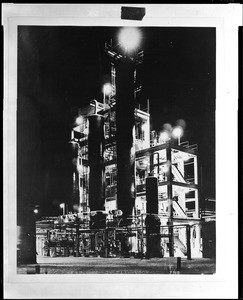 Exterior view of Shell Oil Company refinery at night, ca.1940