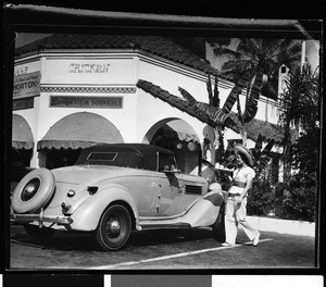 Woman serving food to passengers in a car outside a restaurant