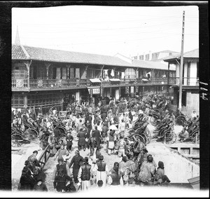 Busy street at a boat landing in China, ca.1900