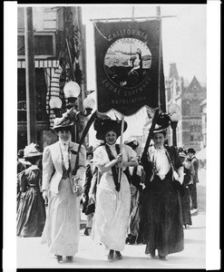 Three women holding a banner promoting women's suffrage in Oakland, ca.1915