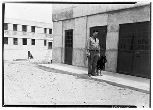 Man and dogs in front of Federal Prison at Los Angeles Harbor, 1938