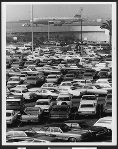 Los Angeles International Airport parking lot, and an airliner beyond it, by James Caldwell, taken in February 1971