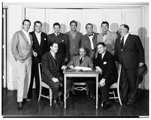 John Wayne and Oliver Hardy posing with a group of men