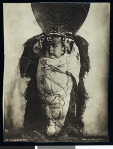 Portrait of a Yakima Indian papoose in a cradle